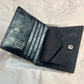 A black distressed calfskin bi-fold wallet from Maison Margiela.