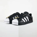 Black Adidas Superstar II shoes with white stripes.